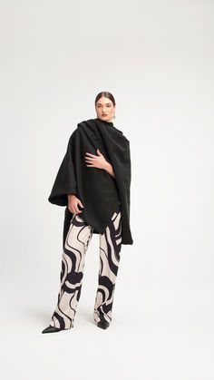 The Wrap Cape is a minimalist yet bold outerwear piece. Crafted from premium soft-touch material, it delivers a luxurious feel and is ideal for layering. Its versatile design allows you to dress it up for special occasions or elevate your everyday look during cooler seasons. Fall Collection, Fall Collections, Everyday Look, Solid Black, Cape, Layering, Special Occasion, Black, Design