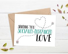 a card with the words sending you socially - distance love on it and leaves around it