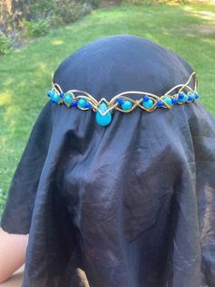 I made this crown with synthetic turquoise beads on the sides, with small blue stone beads woven along the sides, and a synthetic turquoise bead in the center. The wire I used is high-quality gold anodized aluminum and won't rust or tarnish, but just to be safe, probably don't swim with this crown on. (: This crown, like all my others, fastens in the back with a brown suede leather cord, and is very flexible so you can shape it to your very unique head. The flexibility does mean that if you drop it, the crown will bend out of shape. Fortunately, the flexibility makes it easy to bend back in to shape. This crown can be worn as shown in the picture, but I have seen many people who prefer to wear this kind upside down with the point of the stone facing up. This gives the crown more of a 'tiar Elf Crown, Crown Gold, Costume Hats, Anodized Aluminum, The Wire, Turquoise Beads, Bead Weaving, Blue Stone, Sacramento