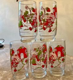 four glasses are sitting on top of a counter with santa clause designs painted on them