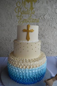 a cake decorated with blue, white and gold ruffles