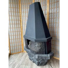 a stone fireplace with a black chimney cover