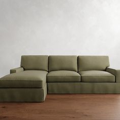 a green couch sitting on top of a wooden floor