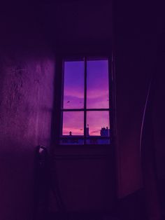 a window that has a purple sky in the background