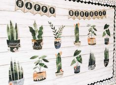 a wooden wall decorated with potted plants and happy birthday banner hanging from the side