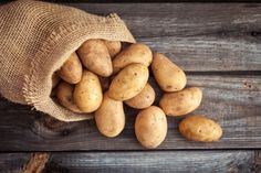 potatoes in a burlock bag on a wooden table