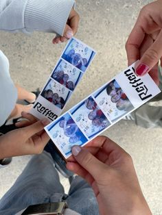 two people holding up some pictures with the same name on them