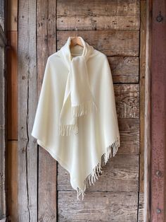 Cream white lambswool poncho cape wit shawl collar Milk white poncho Long wool poncho cape Lambswool poncho warm and light Pure wool One size fits fashionably for most everyone, short or tall, big or small. This piece is versatile for both Men's & Women's outdoor fashion, and can be used insider in cooler winter weather to keep warm while reading on the couch. CARE: Hand-wash and hang to dry, light iron if needed, or dry clean. MEASURES: Length at the front of the neckline to the bottom is ~105