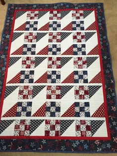 a red, white and blue quilt on the floor