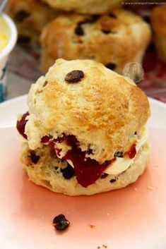 a scone with jam and raisins on it