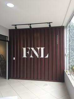 the entrance to fenl is decorated with white letters and black lines on brown shipping containers