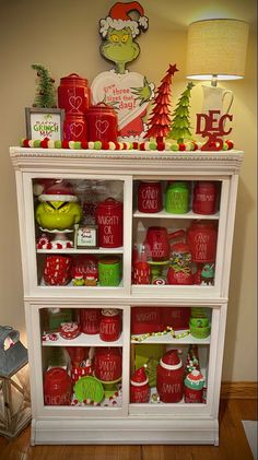 a christmas display with red and green items on it's shelves in front of a lamp