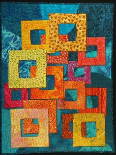 a quilted wall hanging with many different colored squares