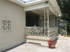 a house with an iron railing and flower pots