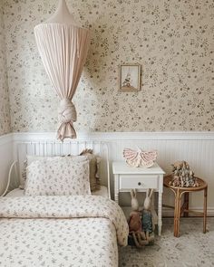 a bed room with two beds and a night stand next to each other in front of a wallpapered wall