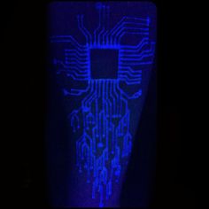 an electronic circuit board lit up in the dark with blue light coming from it's side