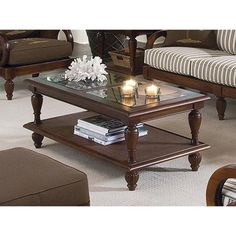 a living room filled with furniture and a coffee table topped with two lit candles on top of it