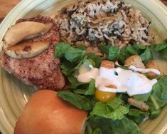 a white plate topped with meat, rice and salad