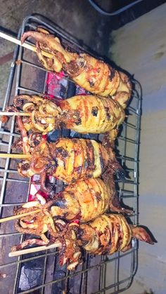 several skewered meats are being cooked on a grill