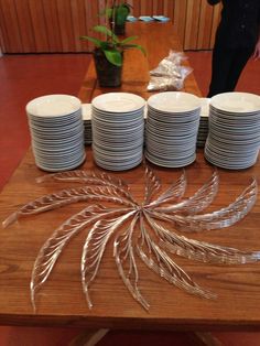 a wooden table topped with lots of white plates