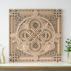 an intricately carved wood panel on a table next to vases and planters