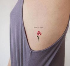 the back of a woman's shoulder with a single rose tattoo on it