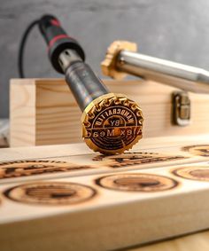 a close up of a bottle opener on top of a wooden board with metal fittings