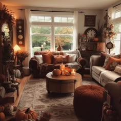 a living room filled with lots of furniture next to a large window covered in pumpkins