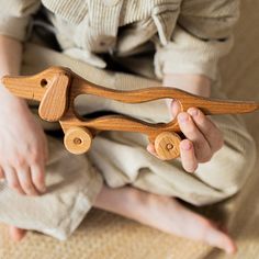 a person holding a wooden toy in their hands