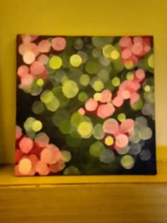 a painting on a shelf with blurry lights in the background