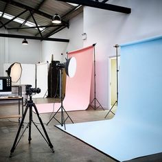 an empty photo studio with soft lighting and backdrops in front of the camera set up