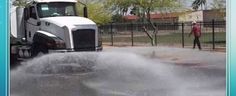 a truck is spraying water onto the street with it's front end and back end