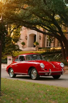 an old red car parked in front of a house