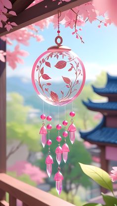 a pink and white wind chime hanging from a tree with flowers in the background