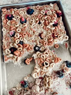 an uncooked pizza with cereal and berries on it