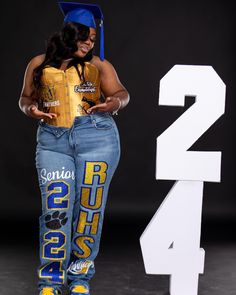 a woman is standing next to a sign and wearing her graduation cap with the number 2 on it