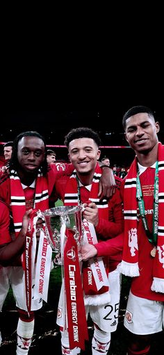 three men in red and white uniforms holding trophies