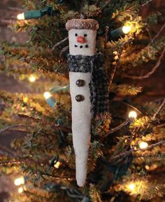 a snowman ornament hanging from a christmas tree