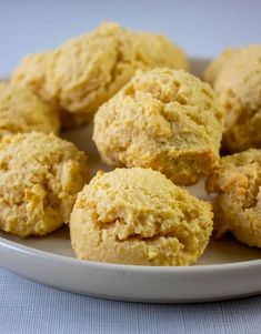 three cornbread muffins with butter on a white plate