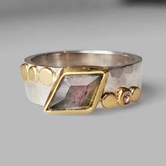 Hints or green and pale pink are a beautiful contrast against the angular shape of this tourmaline. This bi-colored tourmaline set in 18k yellow gold sits atop a hammered faceted silver 6mm band with gold dots on either side with a soft pale pink sapphire accent. Satin finish. Size 6.5. Can be sized upon request. Arrives to you in a special gift box. Purple Sapphire Ring, Purple Sapphire, Gold Dots, Pink Ring, Green Tourmaline, Pink Sapphire, Stone Rings, Sapphire Ring, Tourmaline