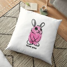 a pink bunny with the words love you on it floor pillow sitting on top of a rug