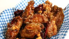 chicken wings with sesame seeds and sauce in a blue basket on a white tablecloth