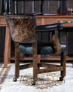 a black leather chair sitting in front of a wooden desk