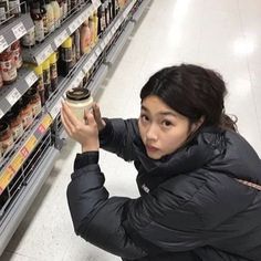 a woman is holding a cup in the store