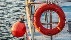 a life preserver and buoy on the side of a boat in the water