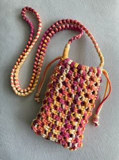 a crocheted purse is laying on the ground with a string attached to it