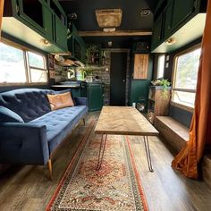 a living area with couches, rugs and windows in the back wall is shown