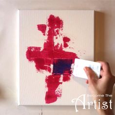 someone is painting a cross on canvas with red and blue paint