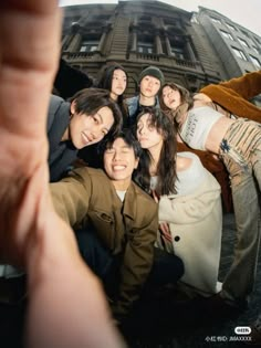 a group of people taking a selfie in front of a building