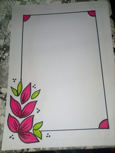 a white paper with pink and green flowers painted on it's edges, sitting on a patterned table cloth